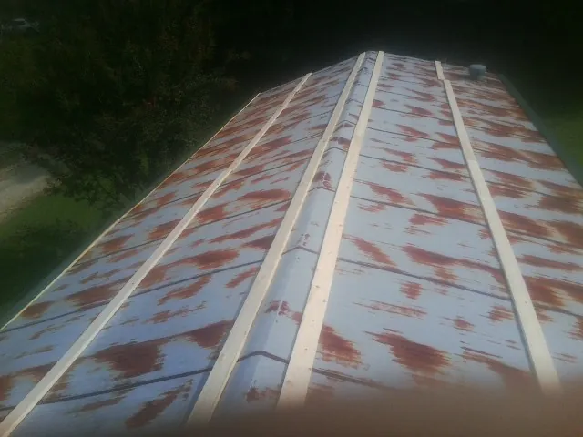 Rusted metal roof panels with new wood purlins before replacement — Storm Damage Roof Repair in Crete by Roofing Brothers